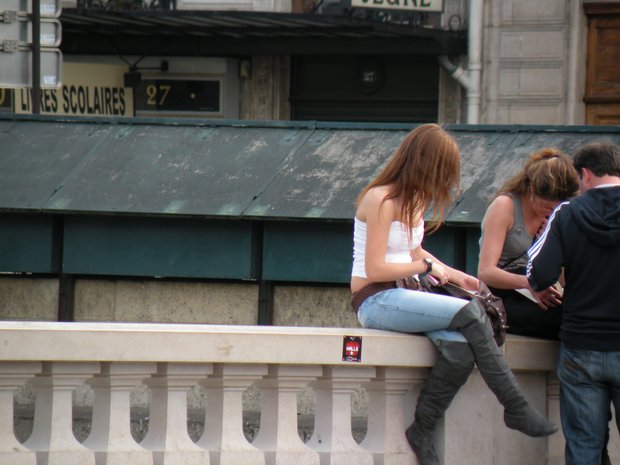  fille assise sur le parapet d'un pont